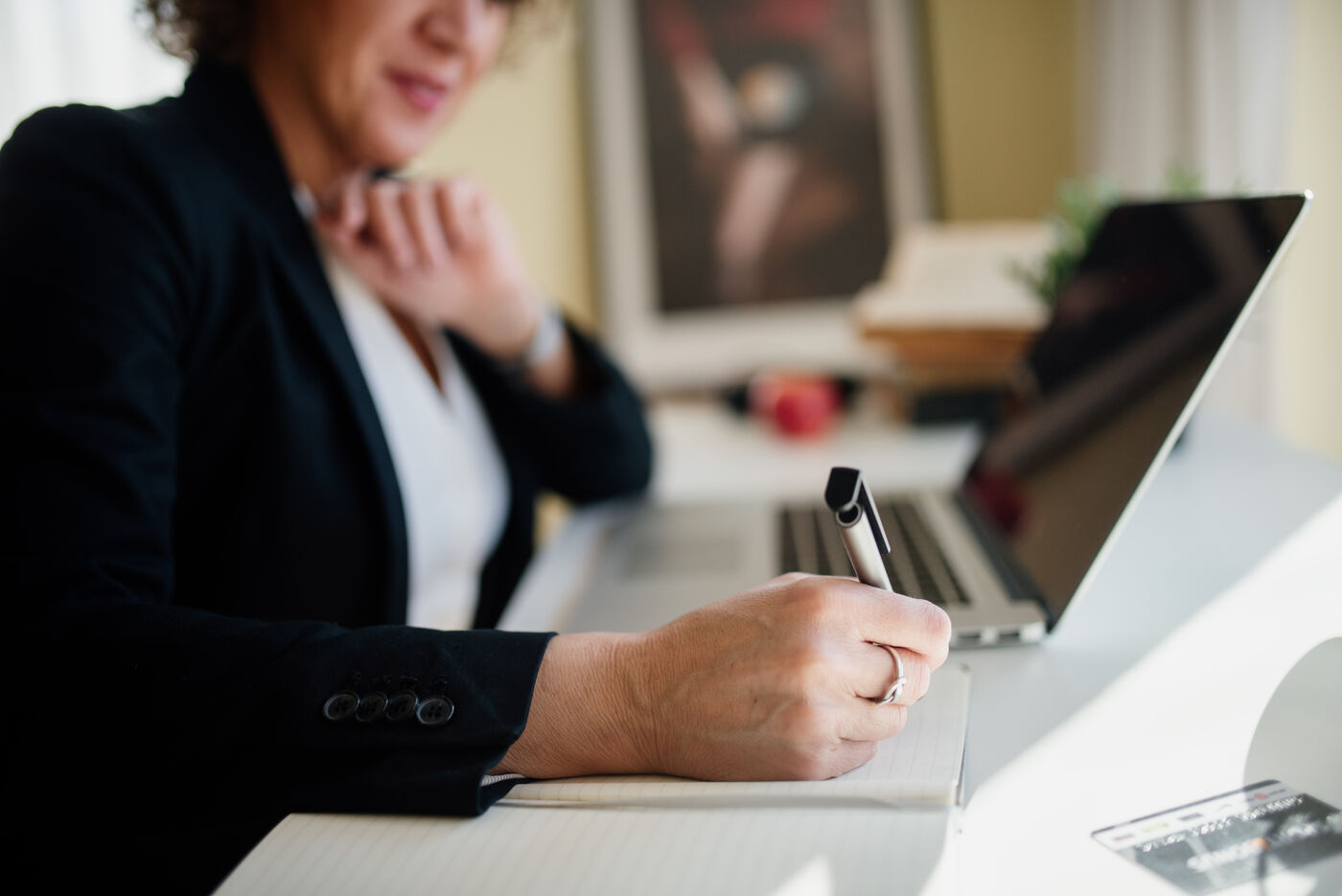 Recruitment advisor reviewing notes alongside a laptop